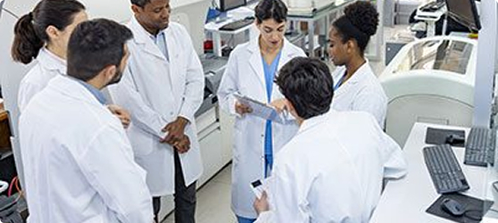 Group of scientists in lab coats standing in discussion