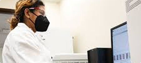 Woman in lab coat standing at computer