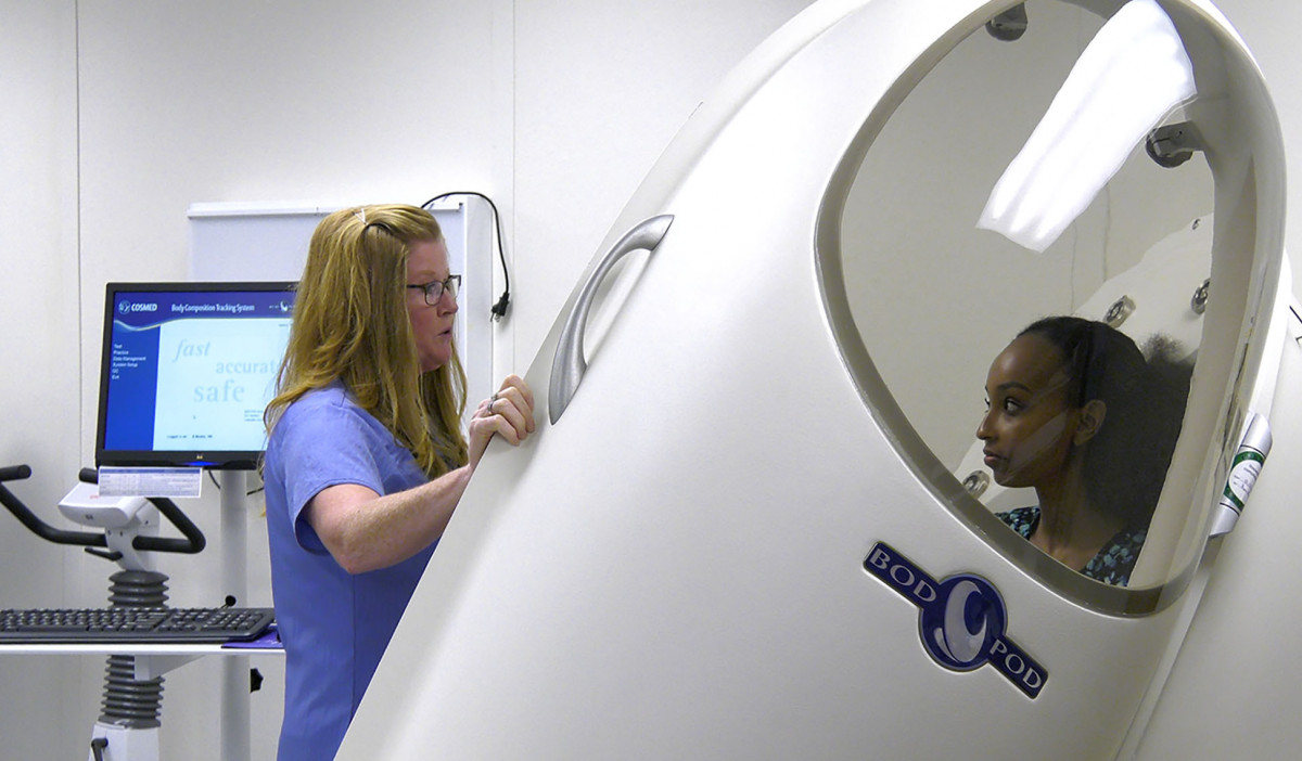 Nurse putting a research volunteer into a Bod Pod