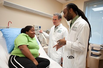 Amanda, a research participant, talks with Senior Investigator Kevin Hall (center) and Staff Clinician Bernard Miller about plans for her two-week stay at the NIH Clinical Center