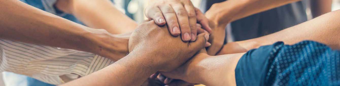 Arms extending their hands together in a "all in" pose. 