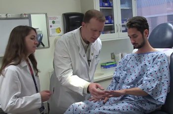 Dermatologists Dominique Pichard (left) and Edward Cowen (center) examine Nancy’s son Charlie’s skin and fingernails, two areas of the body frequently affected by DC and other telomere biology disorders.
