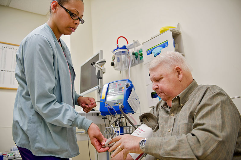 Patient care technician Kia Taylor checks the patient’s vital signs
