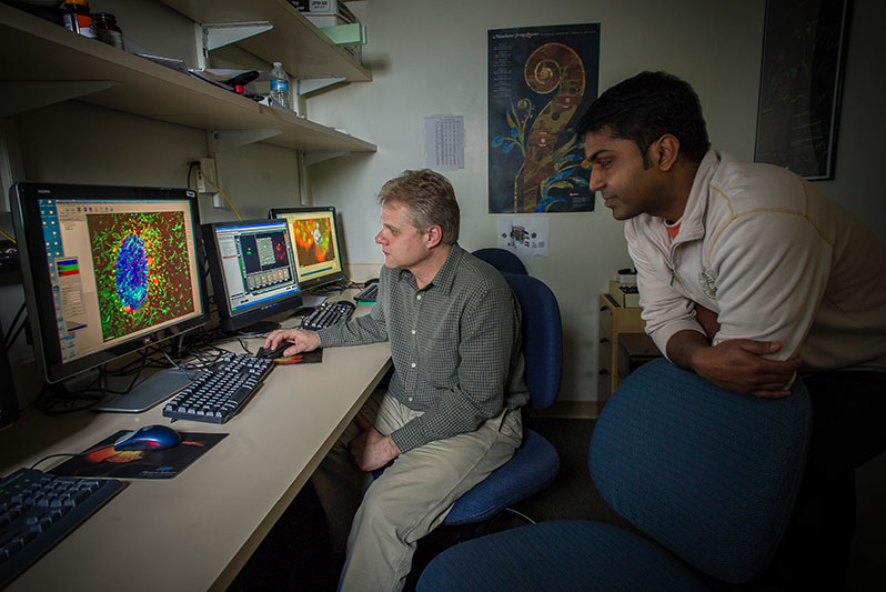Staff scientists Juraj Kabat, Ph.D., and Sundar Ganesan, Ph.D., discussing experimental results