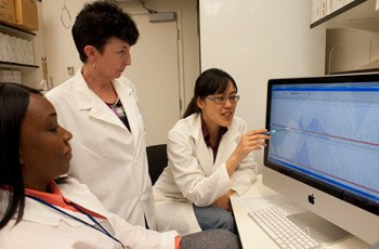 Postdoctoral fellow Xiao-Nan Zhao, Ph.D. (right), and predoctoral fellow Rachel Lokanga (left) discuss their genotyping data with Dr. Usdin