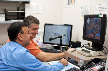 Dr. Zarate and MEG systems analyst Frederick Carver monitor an N-back test inside the MEG unit